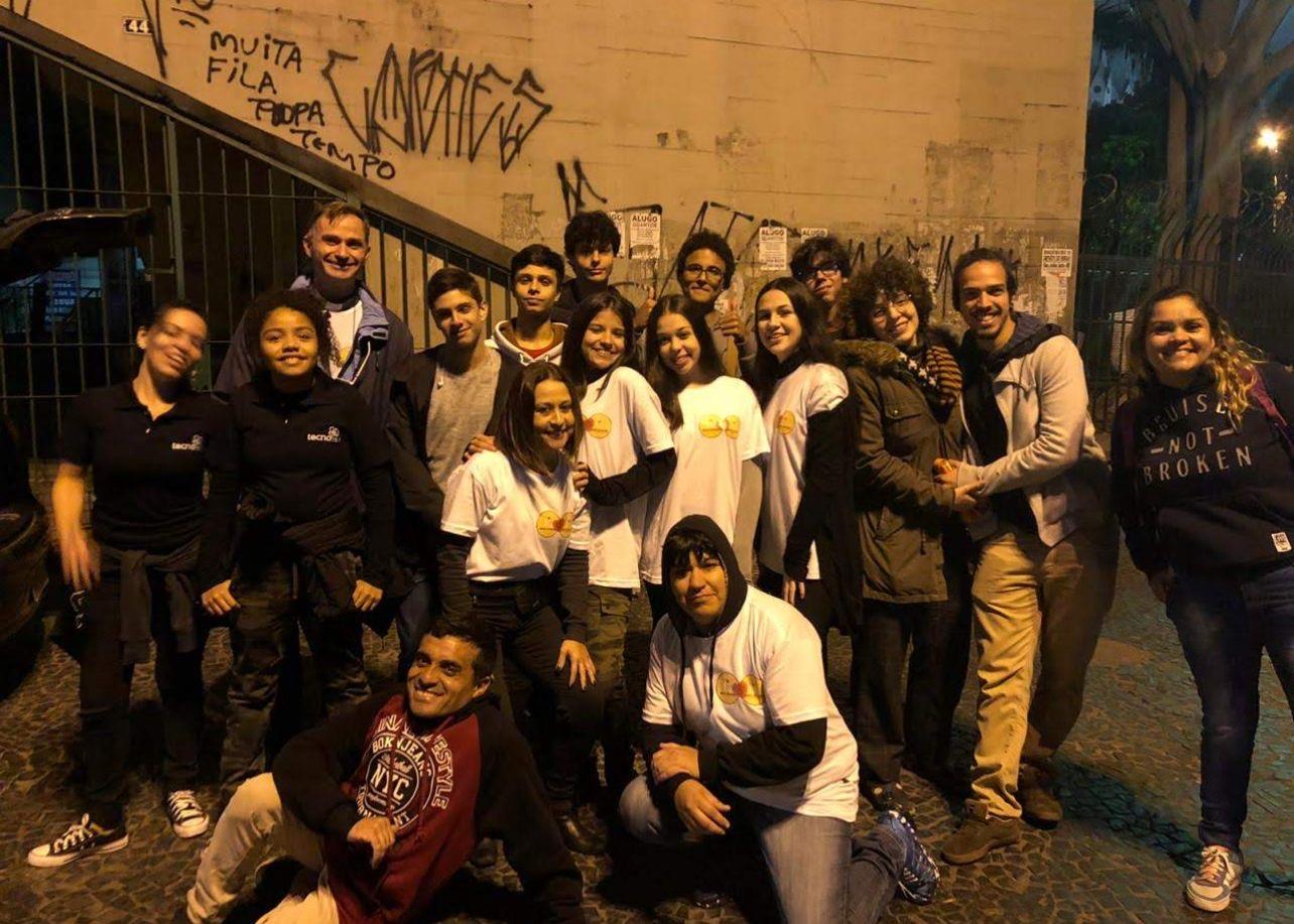 Grupo de voluntários da primeira missão na rua, à noite